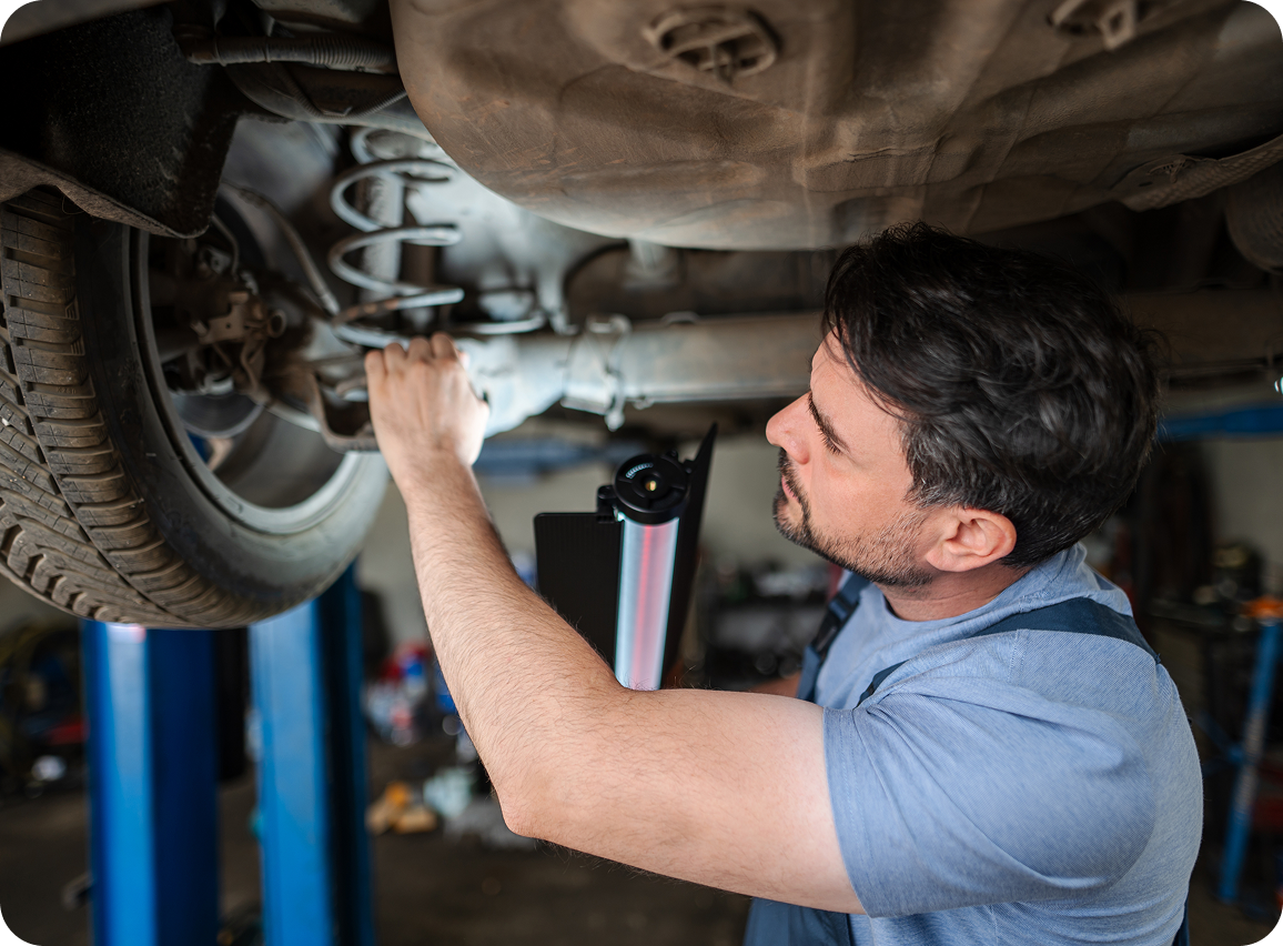 Mechanic inspecting car undercarriage