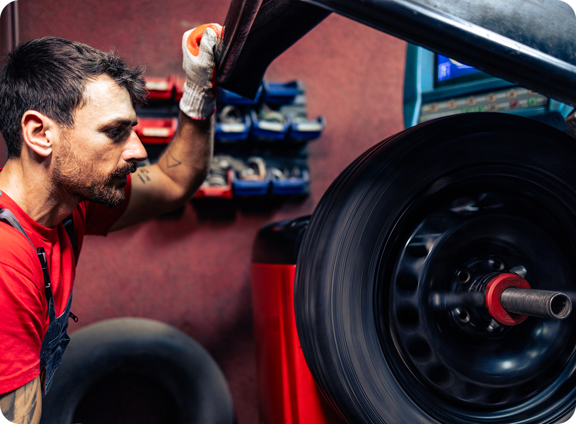 Mechanic inspecting car wheel alignment